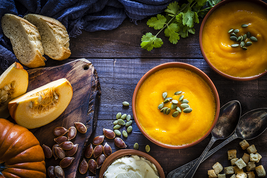 pumpkin-soup-with-ingredients-on-rustic-wooden-table